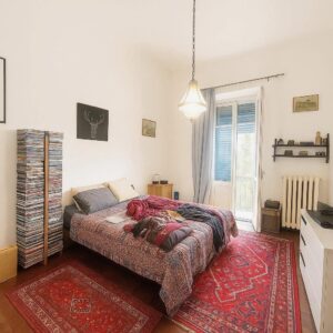 Letti a-resources rossi e tappeto boho villa pisana