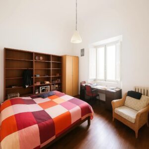 Letto, studio e mobile in legno chiaro con naturale luce, Pisa centro storico.