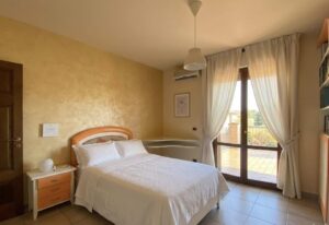 Stanazza accogliente Villa Montecalvoli con letto a baldacchino e vetrate panoramiche.