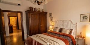 Camera da letto accogliente con letto in ferro, armadio e comodino in appartamento vista mare.