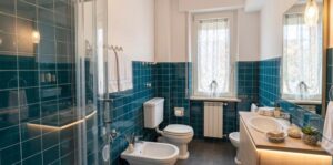 Bagno blu moderno con doccia e finestra sul mare in appartamento vista mare.