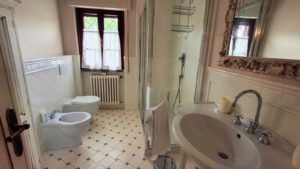 Un bagno tradizionale con checkerie beige, vasca a piedistallo e doccia moderna.