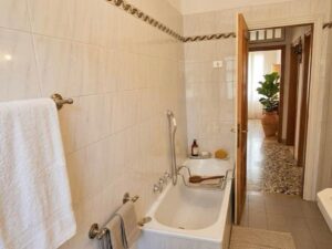 Bagno conmosaico bianco e tubo chromato, luminoso e mediterraneo.