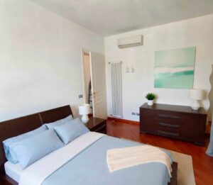 Lettoresco minimalista sereno con letto a grande testata in legno scuro.