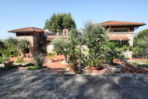 Villa storica dominante e panoramica con parco, piscina e cortile mediterraneo.