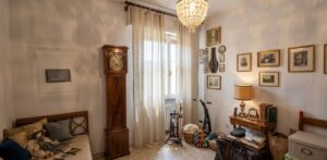Soggiorno vintage con crystal e daybed ruminato, ambientato dallo свет с早晨的第一缕阳光照进充满复古韵味的客厅，水晶吊灯与褶皱灰色枕相伴，营造温馨氛围。