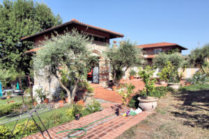 Villa storica dominante e panoramica con parco mediterraneo, casa rustica e ulivi.