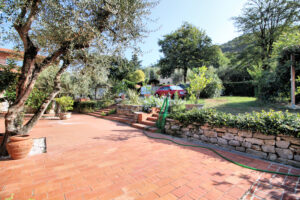 Villa storica con parco mediterraneo, patio in terracotta e vista panoramica dominante.