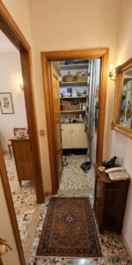 Un corridoio domestico con terrazzo, tappeto tradizionale rosso e m(axe porte di storage accoglienti.
