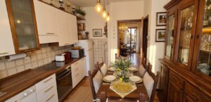 Cucina accogliente con armadietti bianchi e tavolo da pranzo decorato.