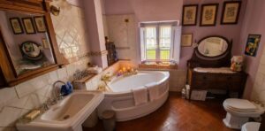 Bagno lavanda in casale toscano vicino Firenze con vasca curva e vanity in legno.