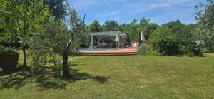 Prato verde e casa moderna in un casale toscano con parco e piscina vicino Firenze.