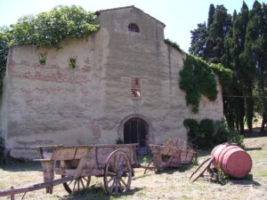 Vecchia chiesa nel vigneto, affreschi sfumati e carri antichi.