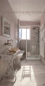 Bagno rosa con vanity bianca, specchio e doccia a pioggia in luce naturale.