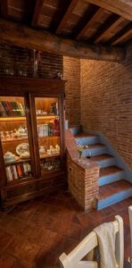 Cassettone in legno e scala blu in mattoni in casale toscano con parco e piscina vicino Firenze.
