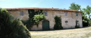 Vecchia fattoria rustica con tetto terracotta in un campo secchione, atmosfera isolata e tranquilla.