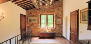 Sala rustica con travi in legno e finestra in un prestigioso casale.
