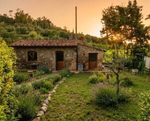 Casale di pietra rustico al tramonto con giardino rigoglioso e colline verdi sullo sfondo