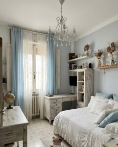 Una stanza serene in blu pastello con chandelier cristallino e mobili vintage.