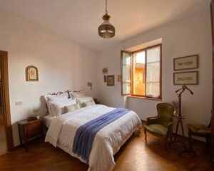 Camera serena con parquet e luce naturale in prestigioso appartamento ristrutturato a Castelnuovo di Garfagnana.