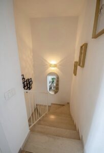 Ascendino minimalista con luce naturale e finestra arco.
