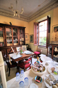 Studio antico elegante con libreria in legno, scrivania d’epoca e tavolo apparecchiato