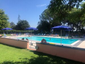 Piscina turca al sole estivo, ombrelloni e rimedi rilassanti.