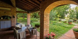 Pergola rustica con griglia e vista giardino, ideale per casale toscano con parco e piscina vicino Firenze.