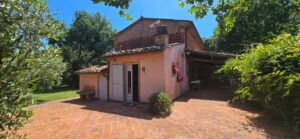Casale toscano con parco e piscina vicino Firenze: casa arancio e vialetto in mattoni.
