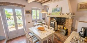 Casale toscano con parco e piscina vicino Firenze: camino in pietra e tavolo bianco.