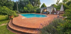 Casale toscano con parco e piscina vicino Firenze: patio, gazebo e giardino soleggiato per relax.