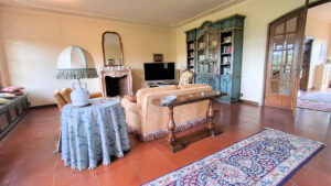 Un soggiorno classico con terracotta, antiche decorazioni e grande bookcase isOpen-close.