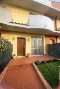 Edificio giallo accogliente con balconata curva e finestre a slider.