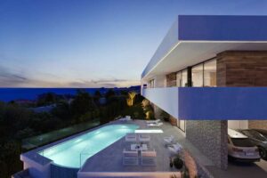 Villa di lusso moderna con piscina illuminata e terrazza panoramica vista mare al tramonto.