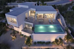 Villa di lusso moderna con piscina a sfioro illuminata in collina al crepuscolo.