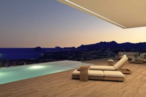 Terrazza moderna di lusso al tramonto con piscina a sfioro e vista panoramica sul mare.