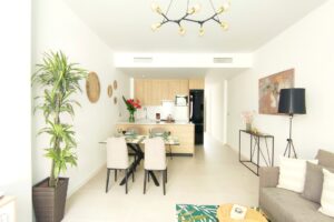 Ampio soggiorno open space moderno con cucina, arredamento elegante, divano grigio e tavolo da pranzo.