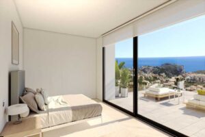 Camera da letto moderna con grandi vetrate e vista panoramica sul mare.