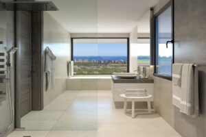 Bagno moderno di lusso con doccia a vista, vasca, doppio lavabo e vista panoramica sul mare.