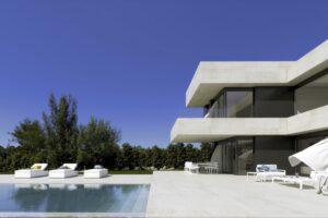 Villa di lusso moderna con piscina, terrazza in pietra e architettura contemporanea a due piani.