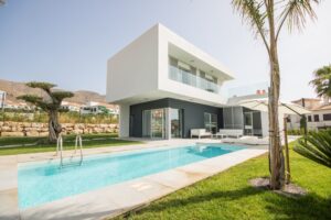 Villa moderna di lusso con piscina, giardino e vista sulle montagne mediterranee.